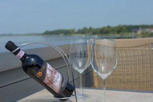 a bottle of wine and two wine glasses on a table at Hiddensee in Wiek auf Rügen