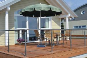 a deck with chairs and an umbrella on a house at Hiddensee in Wiek auf Rügen