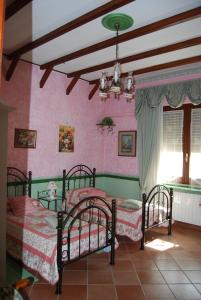 a bedroom with two beds in a room with pink walls at Sette Nani in Elmas