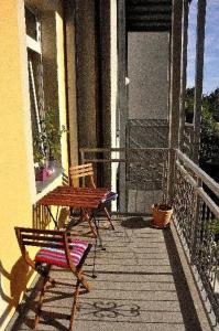 eine Veranda mit 2 Stühlen und einem Tisch auf dem Balkon in der Unterkunft Fewo Dresden Neustadt - zentral & preiswert L5 in Dresden
