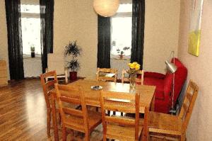 ein Esszimmer mit einem Tisch und einem roten Sofa in der Unterkunft Neustadt -Fewo zentral & günstig L6 in Dresden