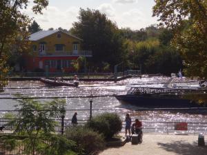 un barco en un río con gente caminando por la acera en Paseo Victorica al 700 en Tigre