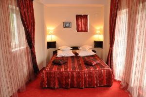 Schlafzimmer mit einem Bett mit roter Bettwäsche und Kissen in der Unterkunft Hotel Golden Beach in Eforie Nord