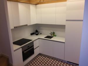 a small kitchen with white cabinets and a sink at Porto Alive in Porto