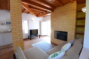 a living room with a couch and a fireplace at O Monte das Flores in Vila Nova de Milfontes