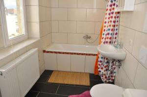 La salle de bains est pourvue d'une baignoire, d'un lavabo et de toilettes. dans l'établissement 4R-Fewo-Altstadtblick-L15, à Dresde