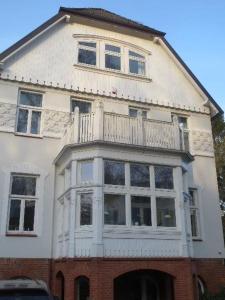 ein weißes Haus mit Balkon darüber in der Unterkunft Düsternbrooker Villa in Kiel
