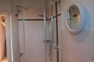 a bathroom with a shower and a mirror at Duesternbrooker-Villa in Kiel +7 photos