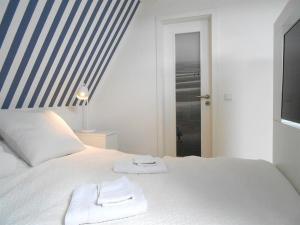 ヴェスターラントにあるHaus-LIV-Appartement-Meerのベッドルーム1室(白いベッド1台、タオル2枚付)