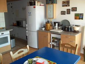 ブランケンハイムにあるFerienwohnungen-Willrich-Ferienwohnung-3のキッチン(青いテーブル、白い冷蔵庫付)