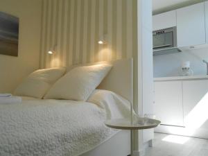 ヴェスターラントにあるHaus-LIV-Appartement-Dueneのベッドルーム(白いベッド1台、テーブル付)