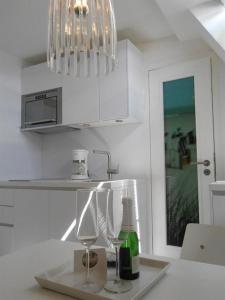 a kitchen with a counter with wine glasses and a chandelier at Haus-LIV-Appartement-Duene in Westerland (Sylt)