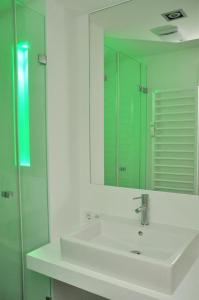 ヴェスターラントにあるHaus-LIV-Appartement-Dueneのバスルーム(白い洗面台、鏡付)