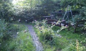 a stone path in a garden with a bench and flowers at Ferienwohnungen-Willrich-Ferienwohnung-3 in Blankenheim
