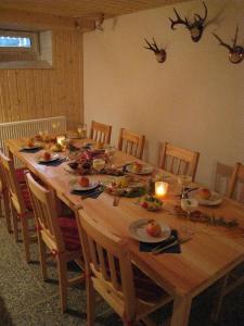 a long wooden table with food and candles on it at Ferienwohnung-1 in Hermsdorf