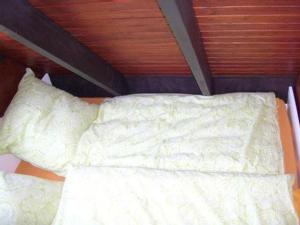 ein Bett mit weißer Bettwäsche und zwei Kissen in der Unterkunft Familienfreundliches Ferienhaus mit Kamin und Waldrand Lage in Blankenheim