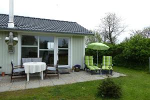 eine Terrasse mit einem Tisch, Stühlen und einem Sonnenschirm in der Unterkunft Ferienhaus Silbermöwe in Kappeln