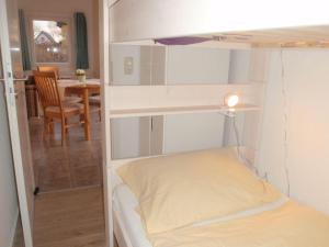 a small bedroom with a bunk bed and a table at Ferienhaus-Silbermoewe in Kappeln