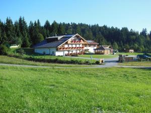 a large building in a field next to a field of grass at Klausgupf in Neureichenau