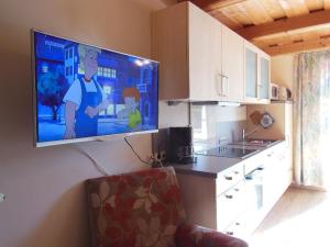 a flat screen tv hanging on a wall in a kitchen at Klausgupf in Neureichenau