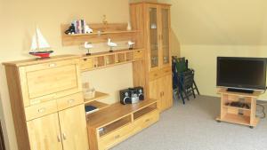 Zimmer mit einem Holzbuchregal und einem TV in der Unterkunft Ferienwohnung "Sophia" in Cuxhaven