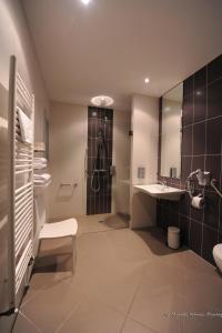 La salle de bains est pourvue d'une douche et d'un lavabo. dans l'établissement Hotel le Broceliande - Sure Hotel Collection by Best Western, à Bédée