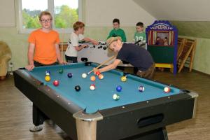 a group of boys playing a game of pool at Ferienhof-Fink-Ferienwohnung-Sonnenblume in Opfenbach