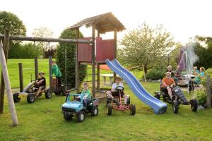 a group of people riding on toy cars on a playground at Ferienhof-Fink-Ferienwohnung-Sonnenblume in Opfenbach