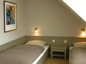 ein Schlafzimmer mit 2 Betten und einem Tisch darin in der Unterkunft SYLT-FERIENHAUS für gehobene Ansprüche  in Erlangen