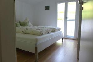 Bett in einem Zimmer mit einer Tür zu einer Terrasse in der Unterkunft Schlemmers Stöckle in Oberried