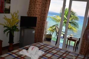 a room with a bed with a view of the ocean at Captngreggs Dive Resort in Puerto Galera
