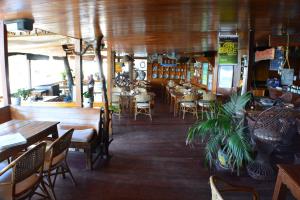 un restaurant avec des tables et des chaises ainsi qu'un bar dans l'établissement Captngreggs Dive Resort, à Puerto Galera