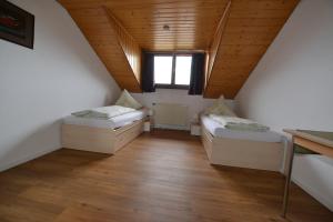 TengenにあるFerienwohnung-Zellerのベッド2台と窓が備わる屋根裏部屋です。