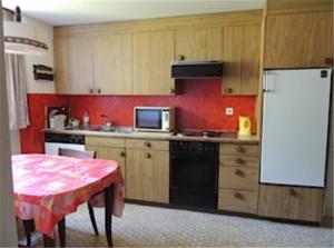 a kitchen with a table and a white refrigerator at Apartments Dr. Med. Vet. Tempelman in Interlaken