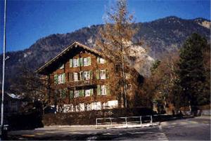 un grand immeuble en face d'une montagne dans l'établissement Apartments Dr. Med. Vet. Tempelman, à Interlaken