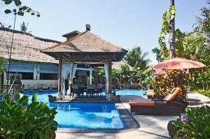 a swimming pool with a gazebo next to a house at Bayside Bungalows in Candidasa