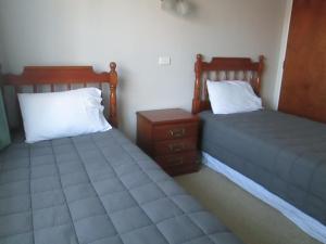 dos camas sentadas una al lado de la otra en una habitación en Awatea Park Motel, en Palmerston North