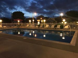 a swimming pool at night with chairs and lights at Cape Harbor Motor Inn in Cape May