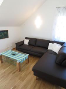 Sala de estar con sofá negro y mesa de centro en Buche, en Überlingen