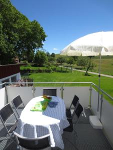 einen Tisch und Stühle auf einem Balkon mit Sonnenschirm in der Unterkunft Buche in Überlingen