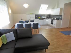 a living room and kitchen with a couch and a table at Buche in Überlingen +5 photos