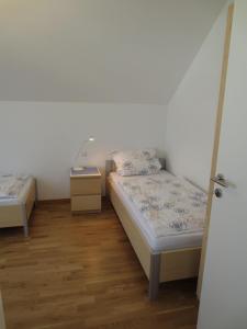 two beds in a small room with wooden floors at Buche in Überlingen