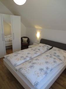 a bedroom with a bed with a white and blue blanket at Buche in Überlingen