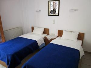um quarto com duas camas com lençóis azuis e brancos em Mochlos Mare em Móchlos