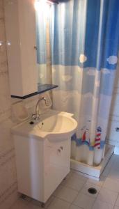 baño con lavabo y cortina de ducha en Mochlos Mare, en Mókhlos