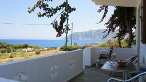 balcón con mesa y vistas al océano en Mochlos Mare, en Mókhlos