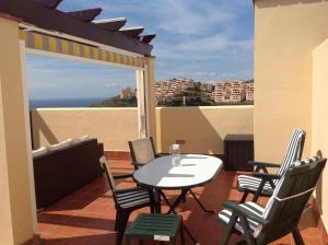 stół i krzesła na balkonie z widokiem na ocean w obiekcie 2 Bed penthouse, rooftop terrace, panoramic views w mieście Mijas