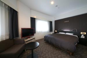 a hotel room with two beds and a television at Shin Osaka Washington Hotel Plaza in Osaka