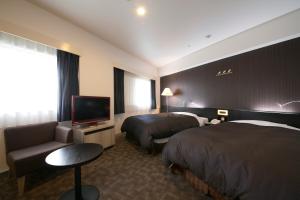 a hotel room with two beds and a flat screen tv at Shin Osaka Washington Hotel Plaza in Osaka +53 photos