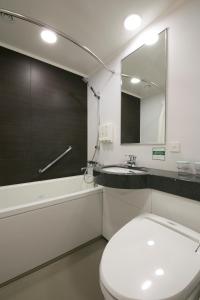 bagno con servizi igienici, lavandino e specchio di Shin Osaka Washington Hotel Plaza ad Osaka